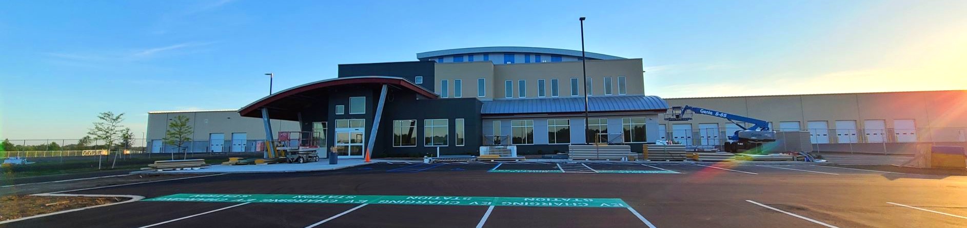 A photo of the nearly-completed new headquarters building on M-211 highway, with the morning sun off to the right.